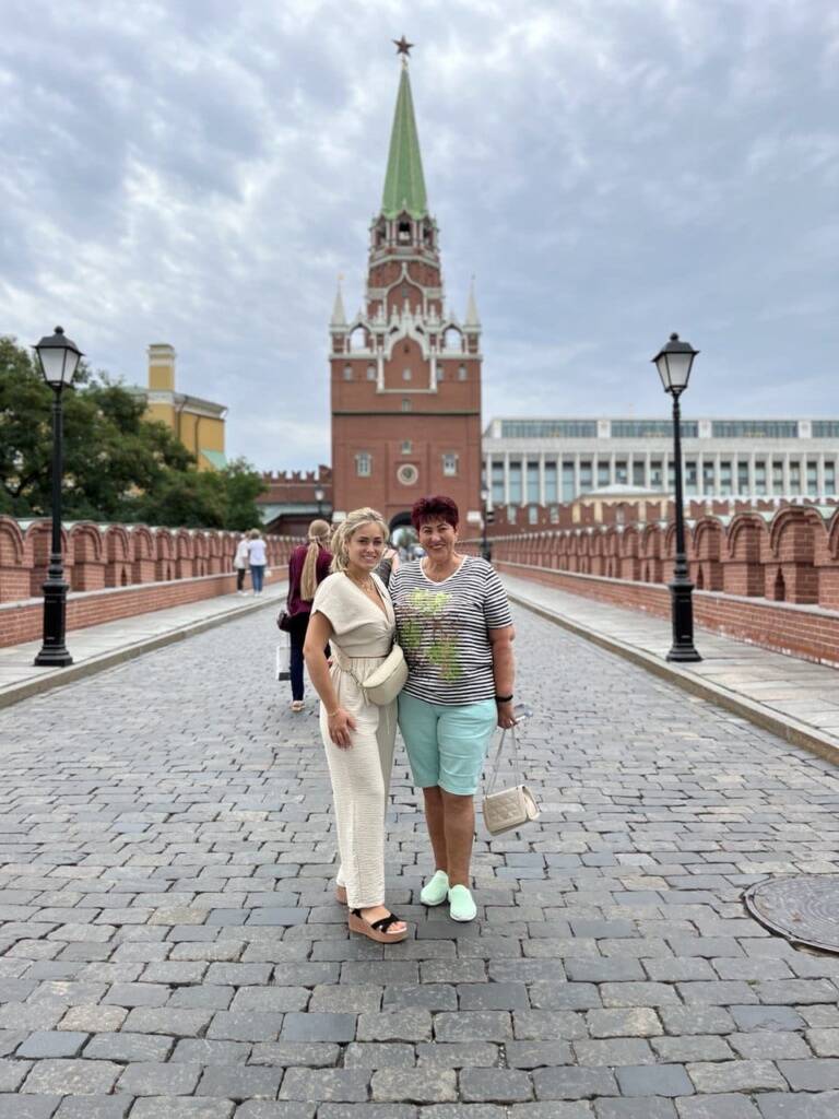 游客们在导游的带领下，在克里姆林宫的三位一体塔附近进行徒步旅行。