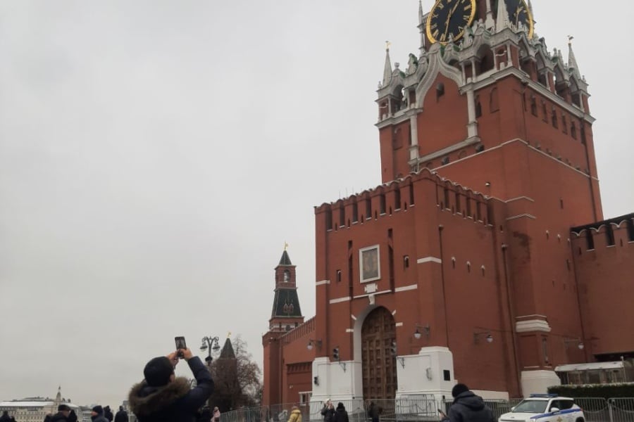 Chinese people on a tour against the backdrop of the Kremlin's Spasskaya Tower