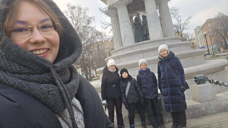 Гид Мария делает селфи с участниками экскурсии на фоне фонтана Наталье и Александр у церкви Большое вознесение, где венчались Пушкин и Наталья Гончарова