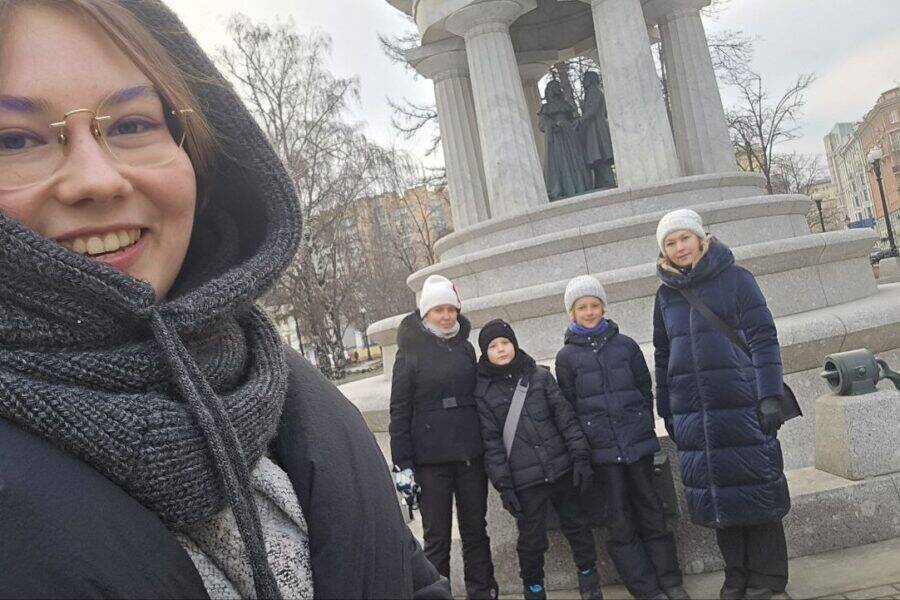 Гид Мария делает селфи с участниками экскурсии на фоне фонтана Наталье и Александр у церкви Большое вознесение, где венчались Пушкин и Наталья Гончарова