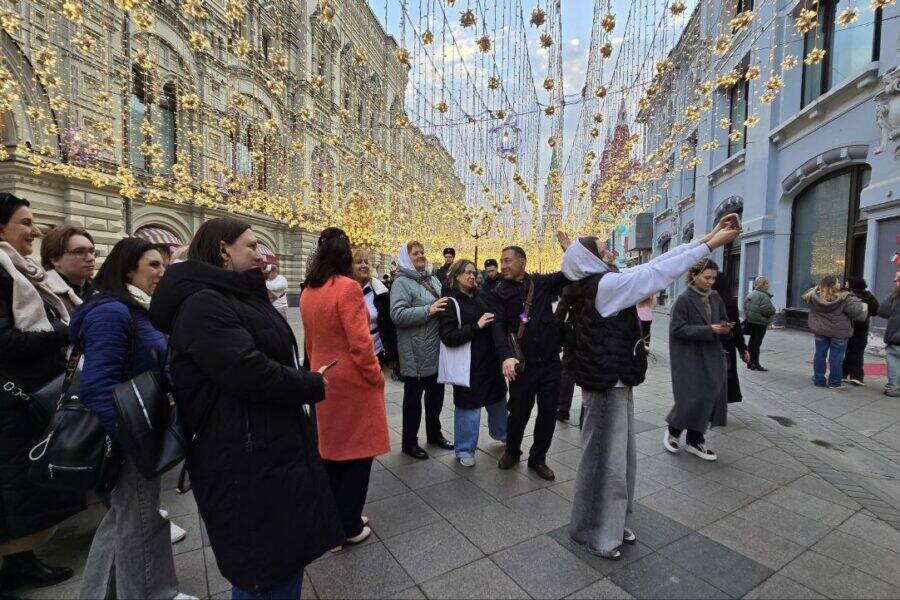 Никольская улица. Группа преподавателей слушает рассказ о московской истории от экскурсовода. Никольская улица. Гид показывает историю Москвы группе преподавателей