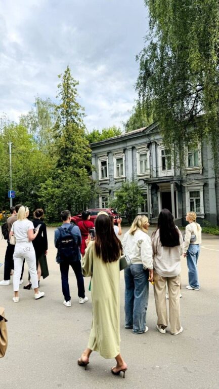 Экскурсанты изучают деревянную дачу булочника Дмитрия Филиппова 1890 года постройки на
пр. Загорского, 10. Прогулка с гидом в районе метро Славянский бульвар.