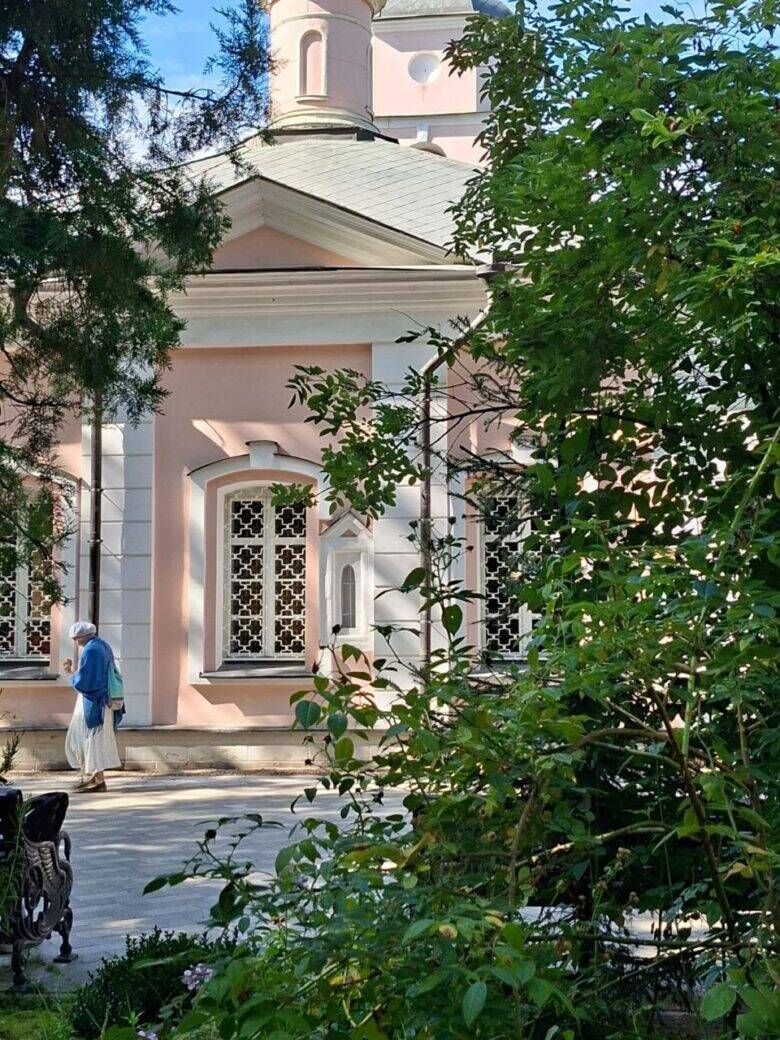 Фасад Покровского храма Розовый фасад храма Покрова Богородицы среди зелени