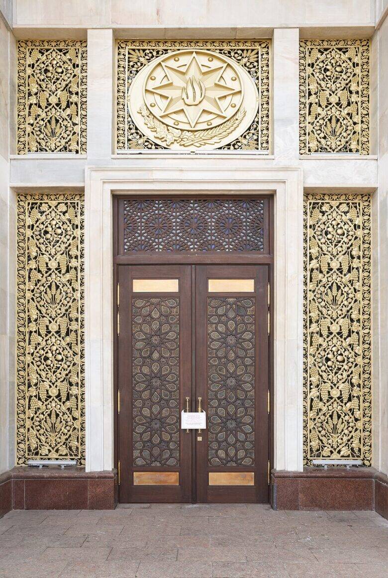 The double doors of the Azerbaijan Pavilion, with a geometric pattern, golden panels and a circular medallion.