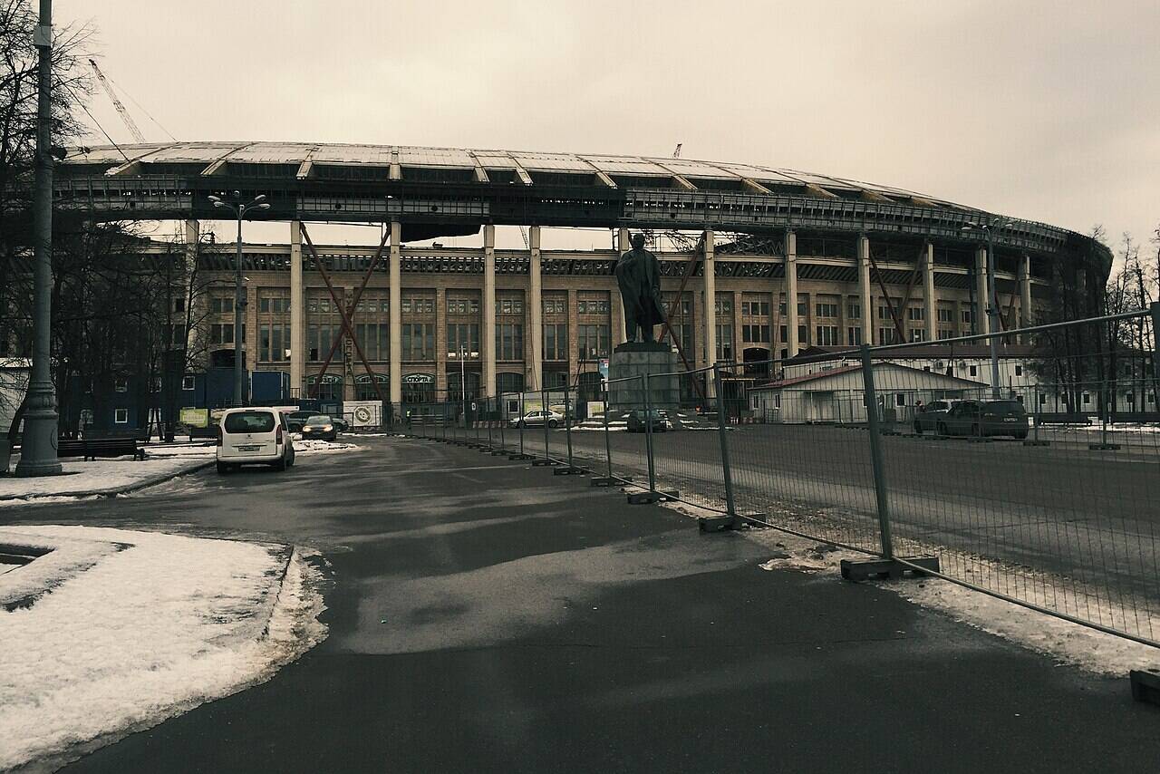 The façade of Luzhniki Stadium with inclined metal supports and a construction crane on 20 January 2015