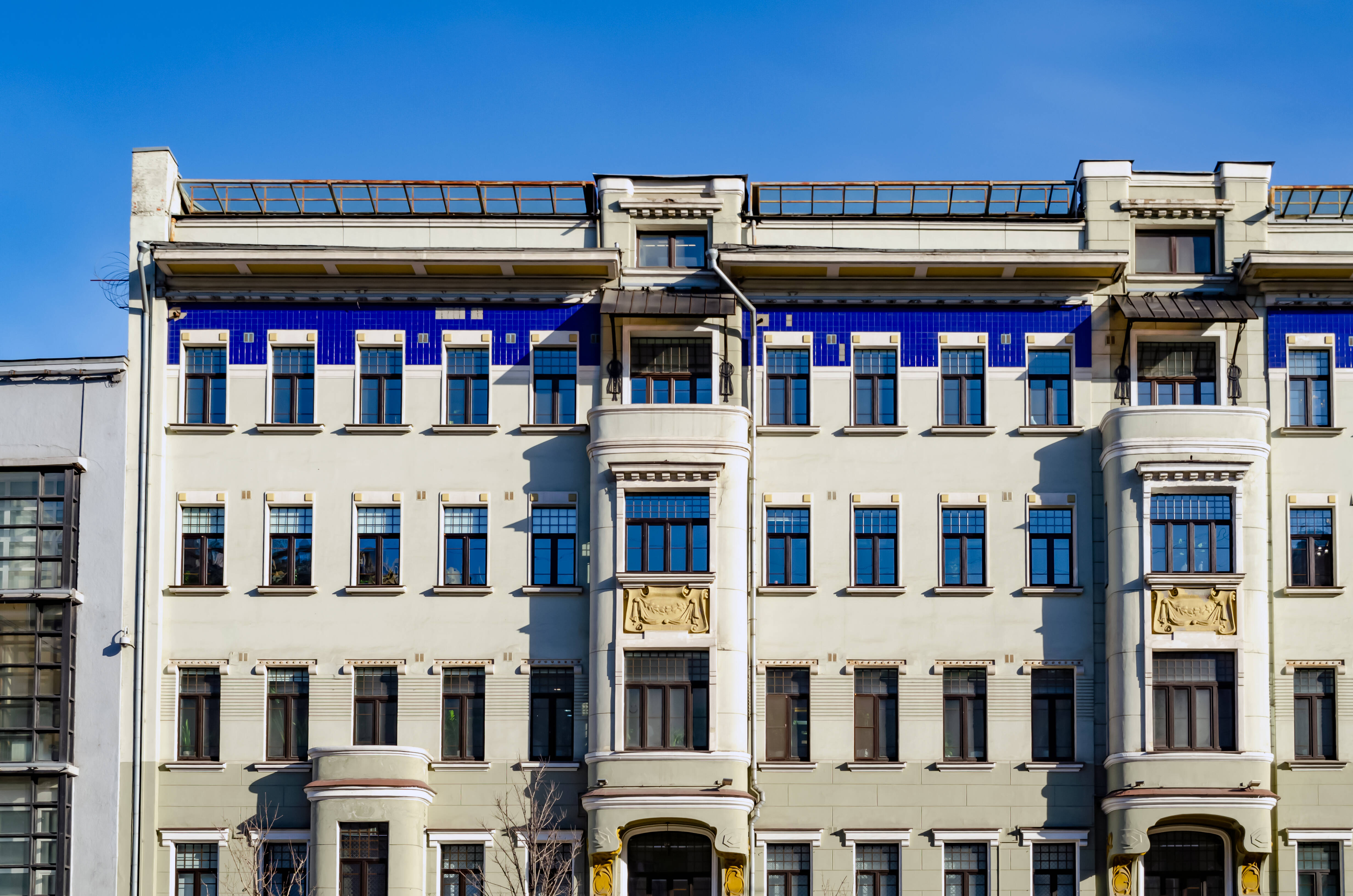 A section of the façade of Pigit House at 10 Bolshaya Sadovaya Street, with bay windows and blue ceramic detailing