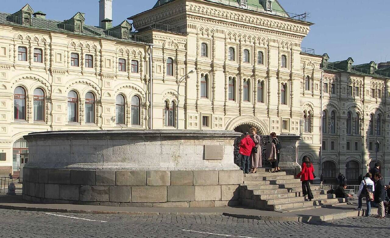 The circular stone parapet of Lobnoye Mesto, with steps on the right and people on the raised platform.