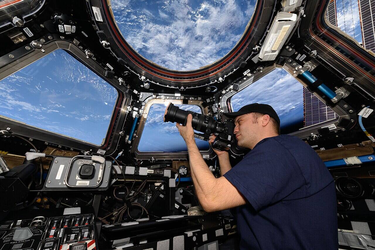 Мэттью Доминик фотографирует Землю через окно модуля Cupola на МКС