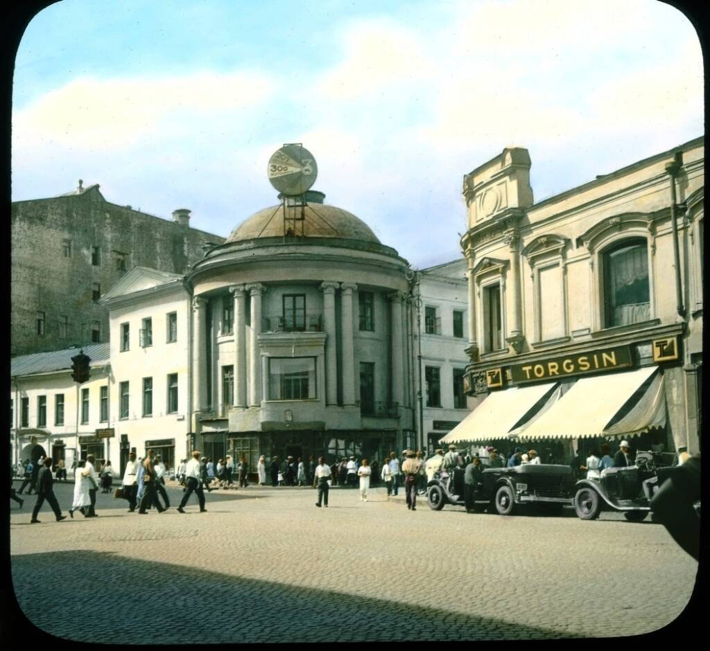 A Moscow Torgsin shop with a TORGSIN sign, pedestrians and cars in 1931
