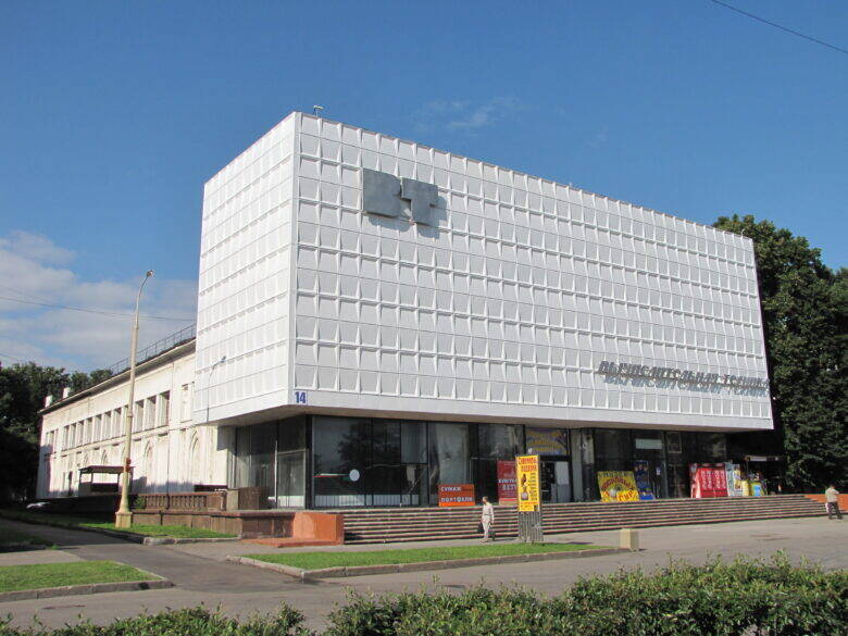 Pavilion No. 14 at VDNKh: a pale façade with relief decoration, the letters ‘VT’ and the number ‘14’ near the corner of the building.
