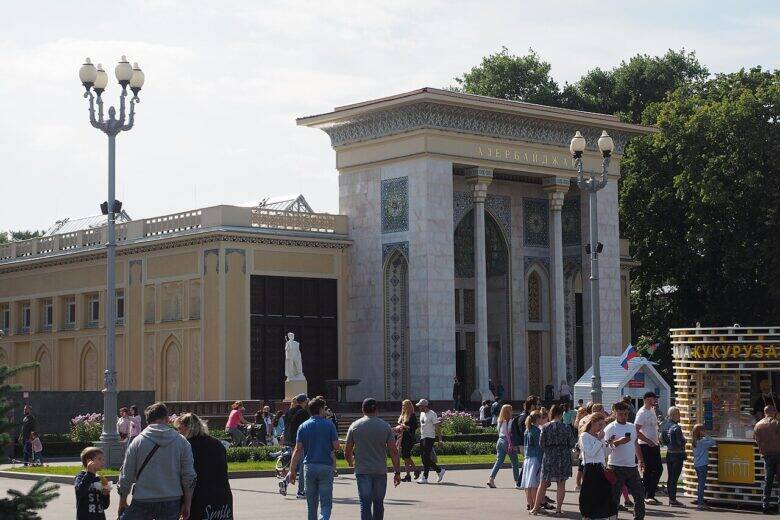 The façade of the ‘Azerbaijan’ pavilion at VDNKh, with its tall, ornate portal; visitors walk in front of the building.