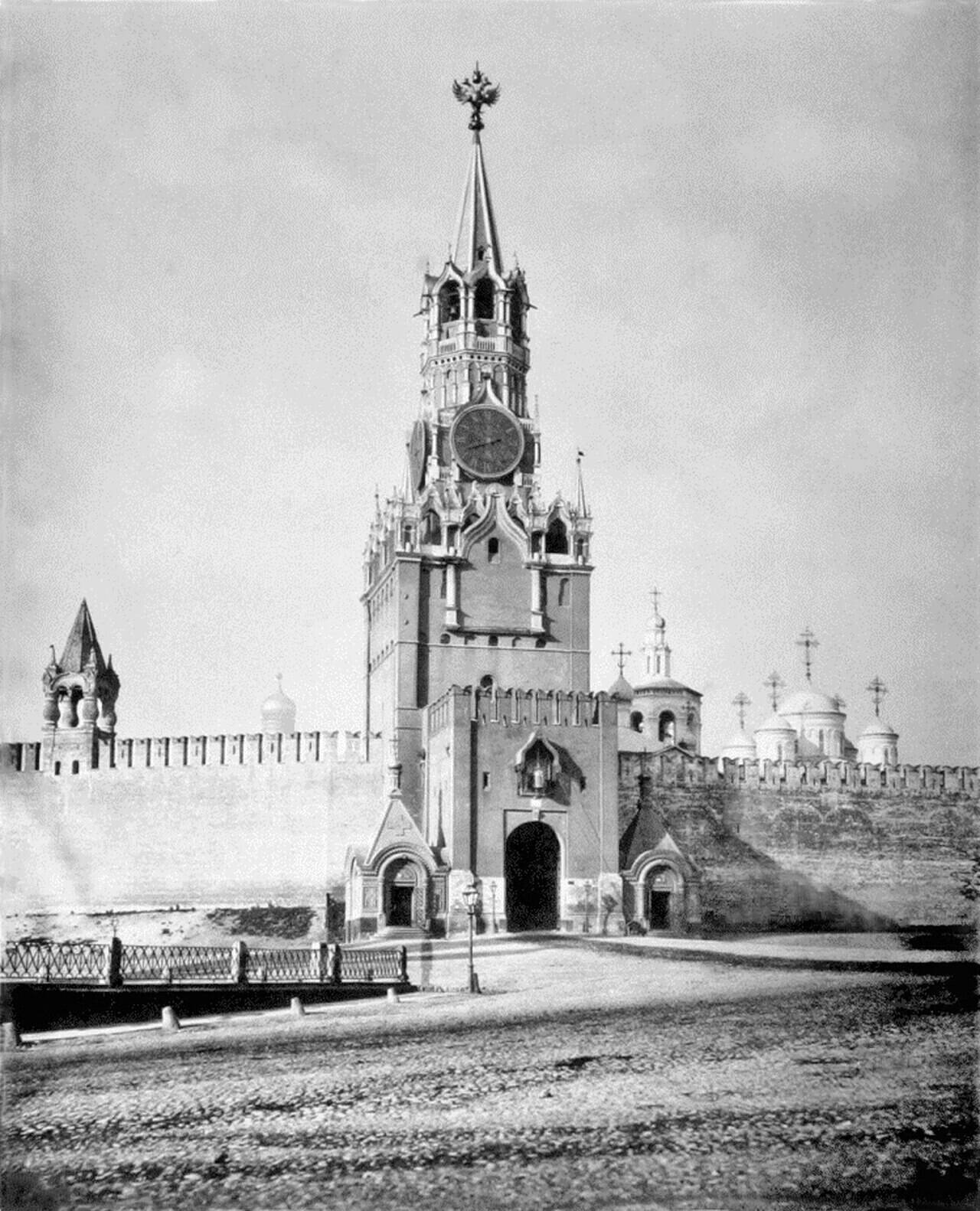 An archival view of the Spasskaya Tower, showing its clock and passageway gates beside the Kremlin wall