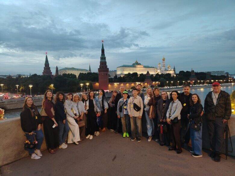 Групповая фотография с видом на Кремль Участники прогулки с гидом на Большом Каменном мосту