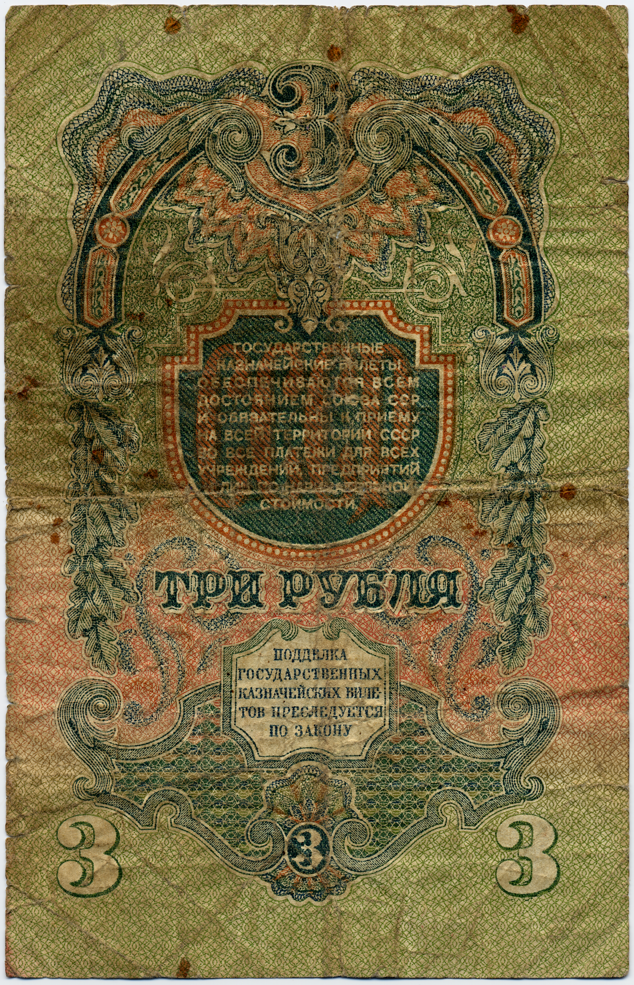 Лицевая сторона потёртой советской банкноты с надписью «ТРИ РУБЛЯ»