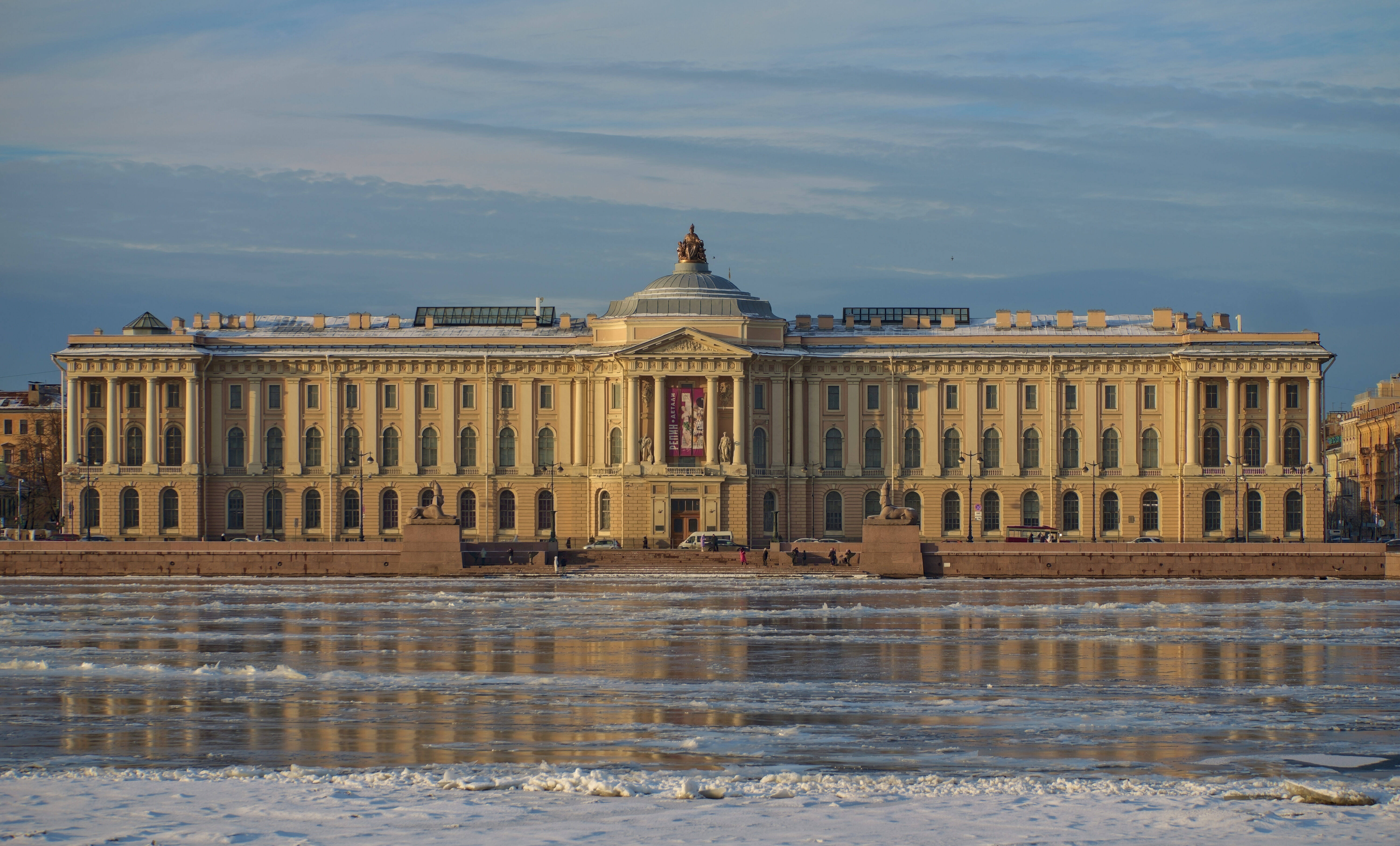 The Imperial Academy of Arts building, with its central dome and sphinxes on University Embankment in winter