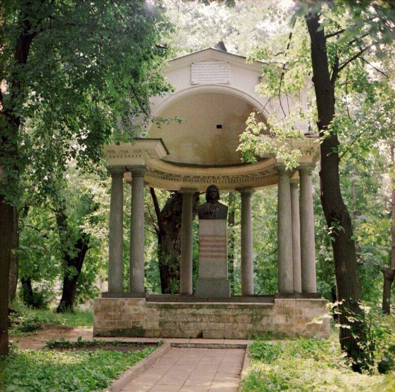 A semicircular pavilion with columns and a bust of Peter I on a pedestal among the trees in Lefortovo Park