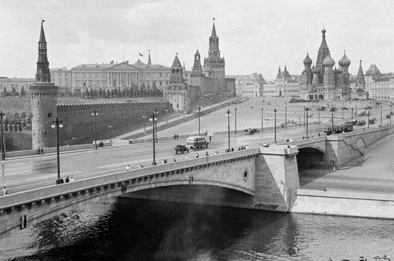 A black-and-white view of Bolshoy Moskvoretsky Bridge with its arched spans; the Kremlin and St Basil’s Cathedral are visible beyond the bridge.