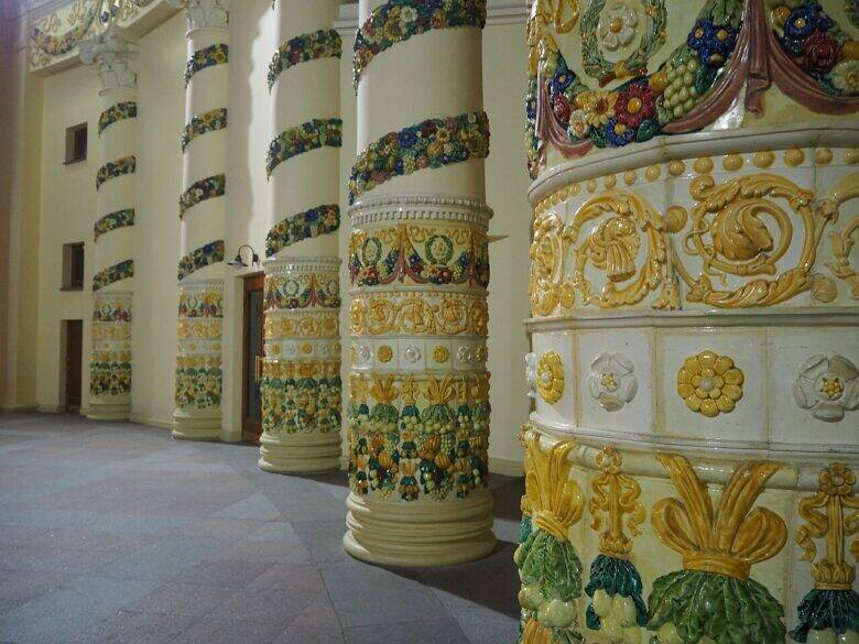 A row of columns at the Belarus Pavilion at VDNKh, with colourful garlands and botanical relief decoration.