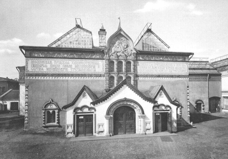 Black-and-white front view of the Tretyakov Gallery: an equestrian relief sits above the central arch, flanked by inscribed panels.