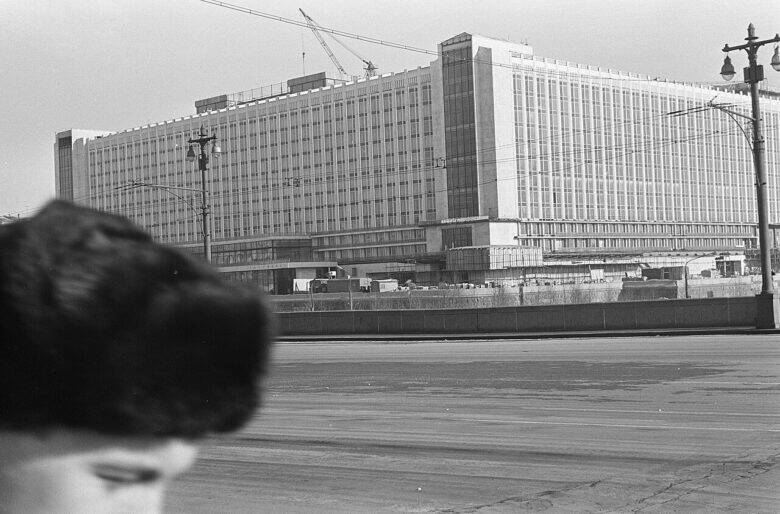 A black-and-white view of the Rossiya Hotel in Moscow: a long façade, a crane and a road in the foreground.