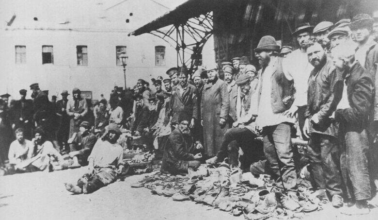 People beside old shoes laid out for sale in an archival photograph of Khitrovsky Market