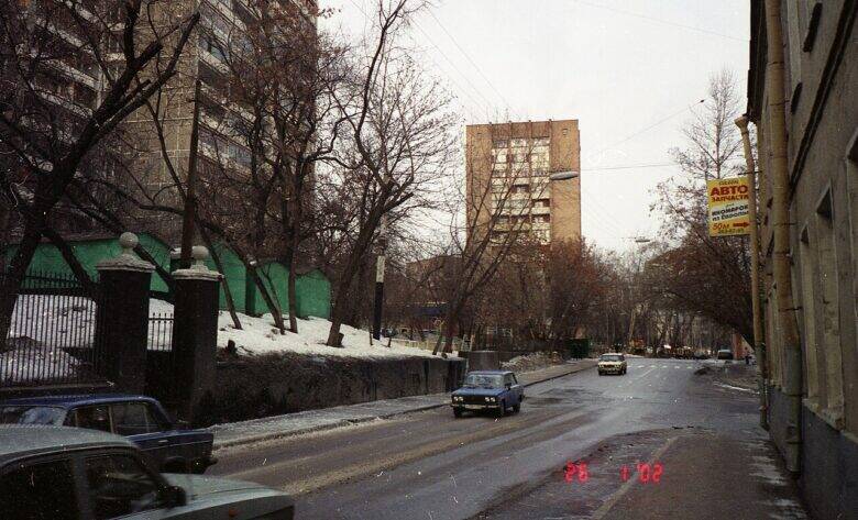 Зимний вид Малой Почтовой улицы: автомобили на дороге, снег у тротуаров и дома вдоль улицы.