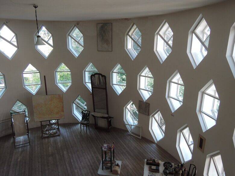 The studio in the Melnikov House with rows of hexagonal windows, an easel and chairs