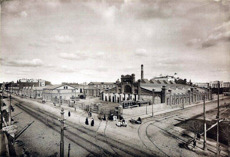 An archival overview of the Miussky tram depot: buildings behind a fence, streets with tram tracks, pedestrians and horse-drawn carts.