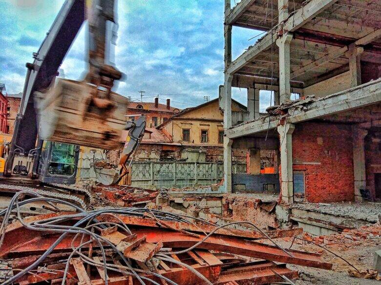 An excavator amid construction rubble; the historic house known as Anna Mons’s House is visible behind the fencing.