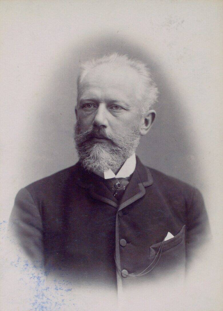 A studio portrait of Pyotr Tchaikovsky with a grey beard, wearing a dark suit.