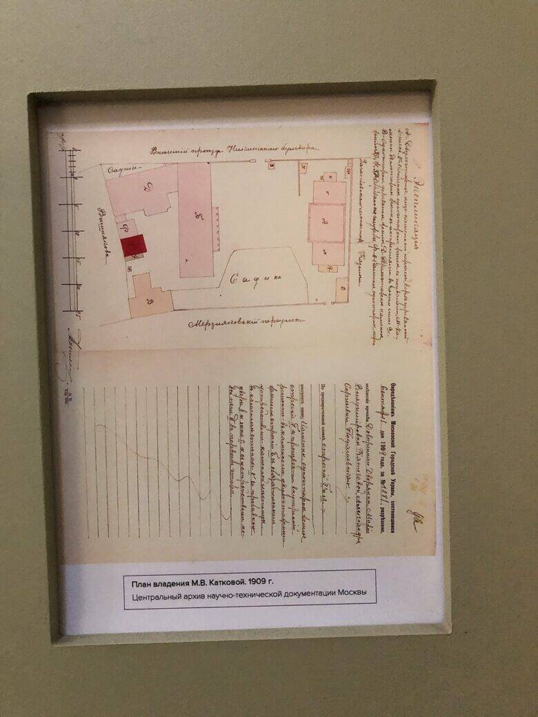 A floor plan framed behind glass, with a museum label beneath it.