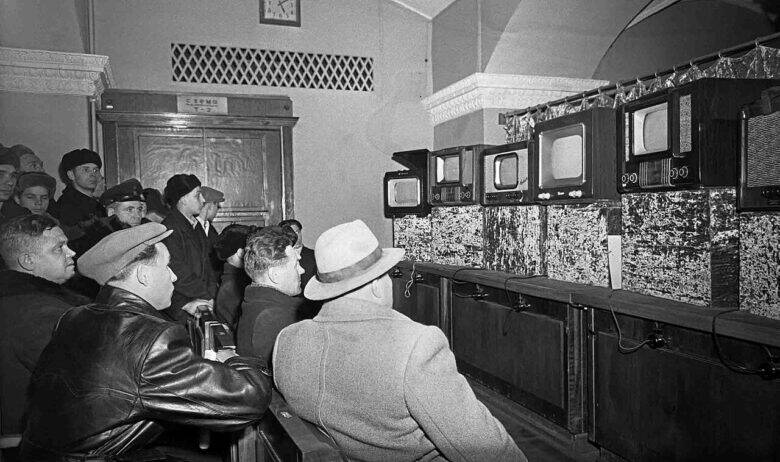 Посетители перед рядом телевизоров в Демонстрационном зале ГУМа в декабре 1954 года