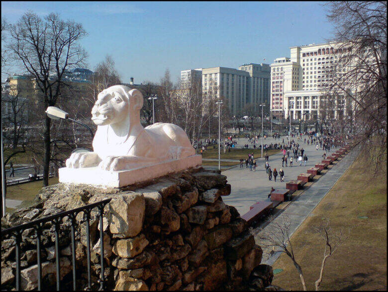 White sculpture of a reclining lion on the stonework above the grotto in Alexander Garden
