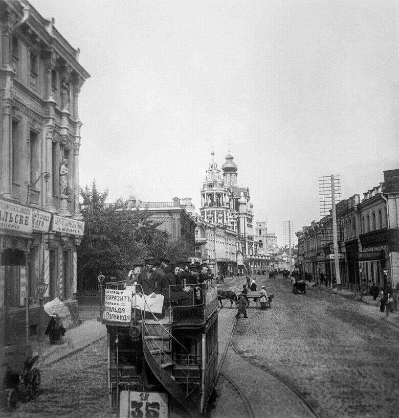 A horse-drawn tram with passengers on the upper deck travels along the tracks on historic Pokrovka Street.