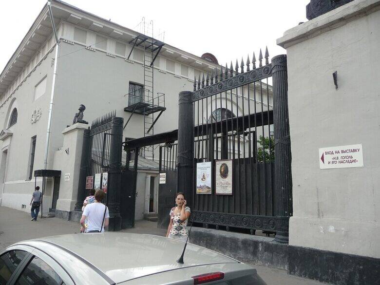 A pale building of the Provision Warehouses and black metal gates on the street side.