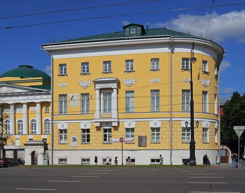 The yellow Moscow University building on Mokhovaya Street, with a rounded façade and white decorative details.