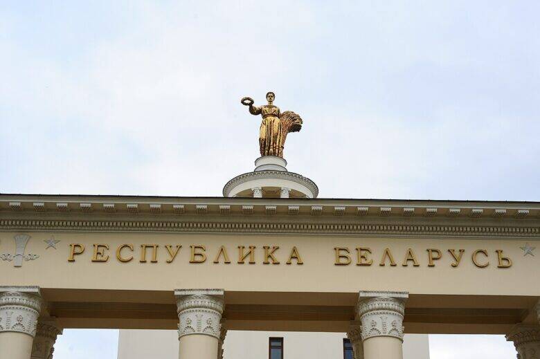 A golden figure holding a sheaf on the tower of the ‘Republic of Belarus’ Pavilion, above the inscription ‘REPUBLIC OF BELARUS’.